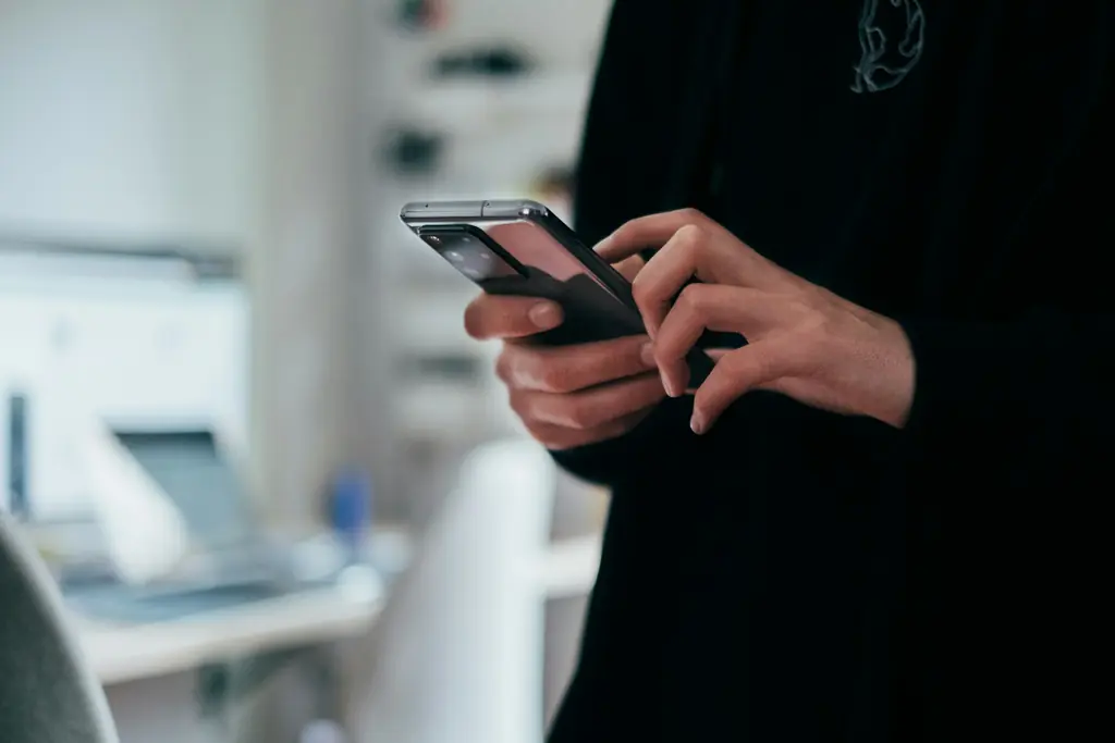 Manos sosteniendo un teléfono inteligente
